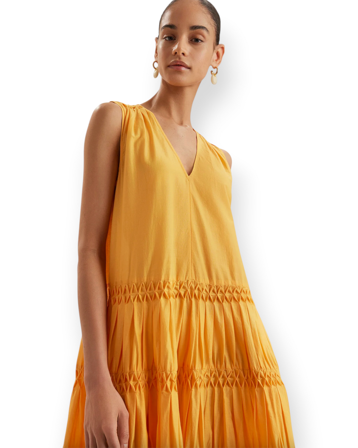 Birdie by Nina Liddle Design yellow Pima cotton midi dress with V-neck and honeycomb smocking on a model