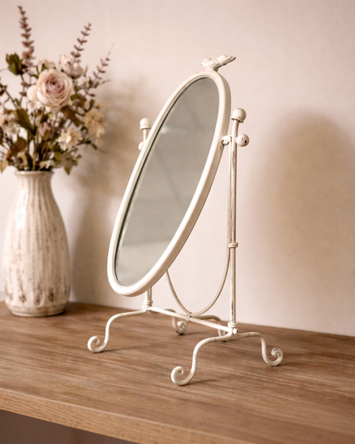 Birdie by Nina Liddle Design vintage oval table top swing mirror with a distressed white finish on a wooden surface