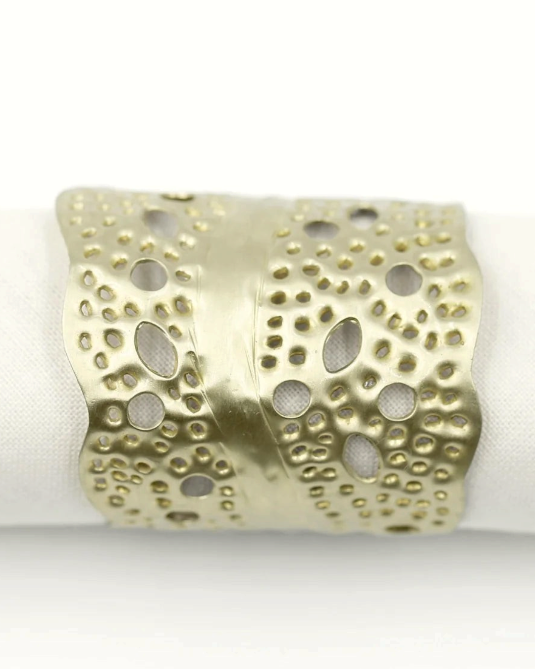 Birdie by Nina Liddle Design gold sea kelp napkin ring with intricate cut-out leaf pattern on a white napkin