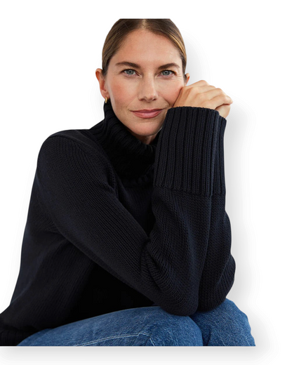 Birdie by Nina Liddle Design model wearing a black ribbed Turkish cotton turtleneck sweater with a relaxed fit.