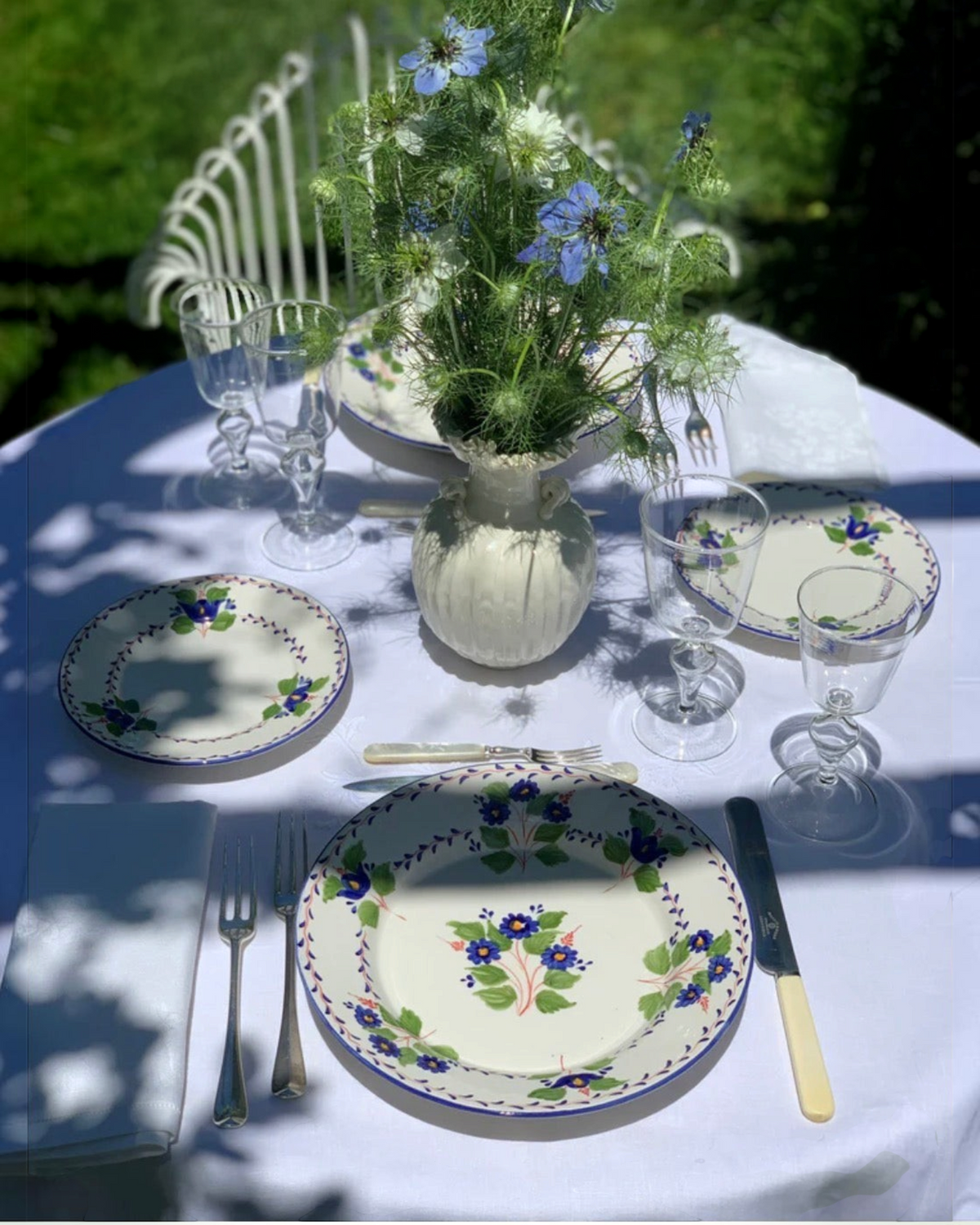 Birdie by Nina Liddle Design Fleur ceramic dessert plates with blue floral patterns set on an outdoor garden table