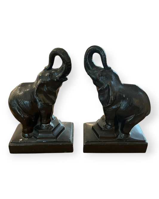 Birdie by Nina Liddle Design vintage brass elephant bookends with trunks raised on square bases for bookshelves.