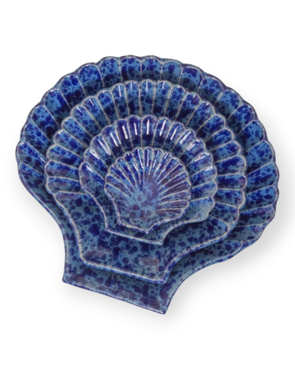 Birdie by Nina Liddle Design set of four blue ceramic Concha shell-shaped plates with a speckled glaze finish.