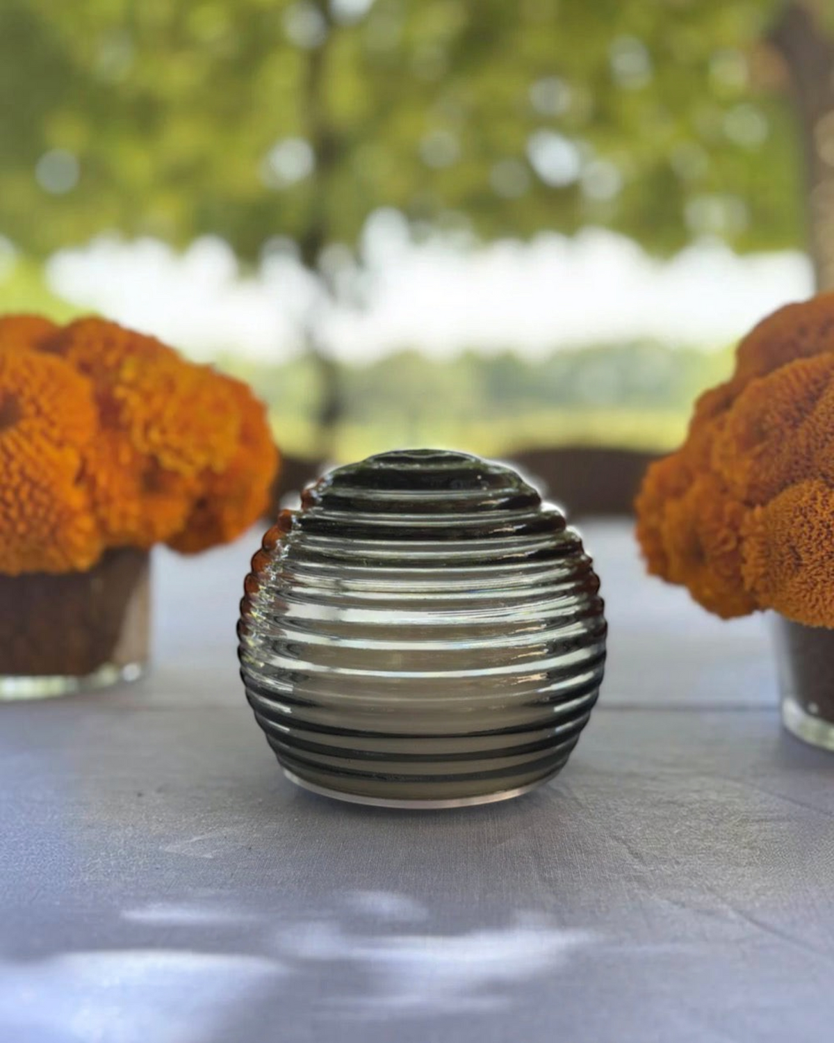Birdie by Nina Liddle Design handblown Murano glass portable table light with concentric rings on a garden table