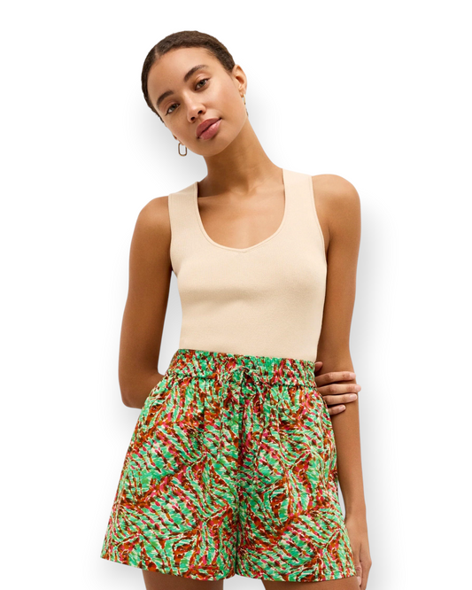 Model wearing a Birdie by Nina Liddle Design beige ribbed knit Miranda tank top tucked into patterned shorts