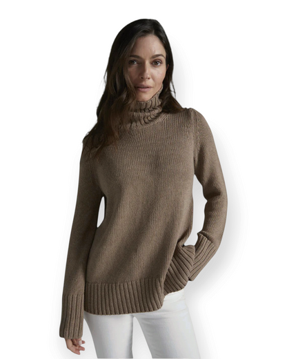 Model wearing a Birdie by Nina Liddle Design brown cotton turtleneck sweater with ribbed cuffs and a relaxed fit.